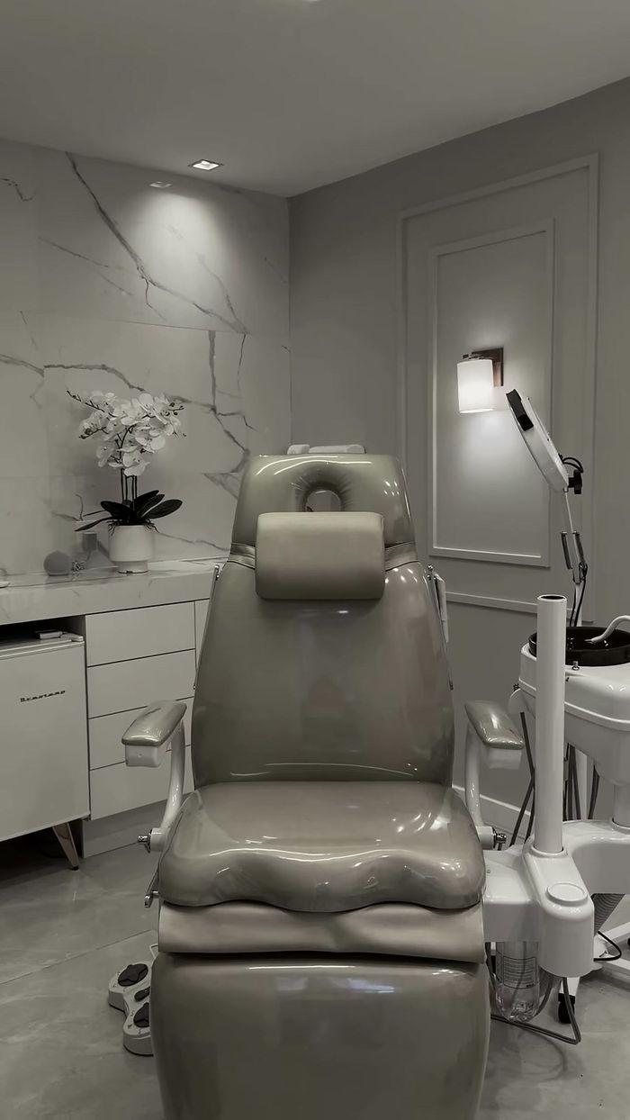 Sala de atendimento da Clínica Zeni, com cadeira odontológica e orquídea